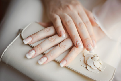 bride's arms with manicure holding a wedding purse
